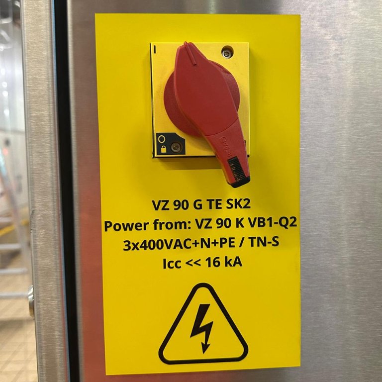 Plaque d'avertissement jaune avec spécifications électriques et pictogramme éclair sur armoire électrique